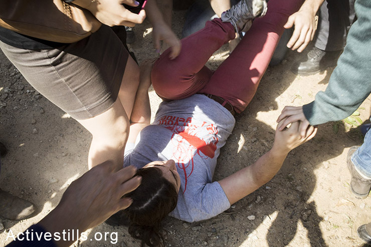 ספיר סלוצקר, פעילה, שרועה על הקרקע לאחר שהופלה ע"י שוטרי משמר הגבול. מאוחר יותר ספיר נעצרה ע"י המשטרה. (צילום:קרן מנור/אקטיבסטילס)