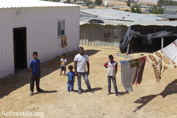 עיאד עדיסאן עומד עם ארבעה מתוך 8 ילדיו מחוץ לביתם אשר בסכנת הריסה (אקטיבסטילס)