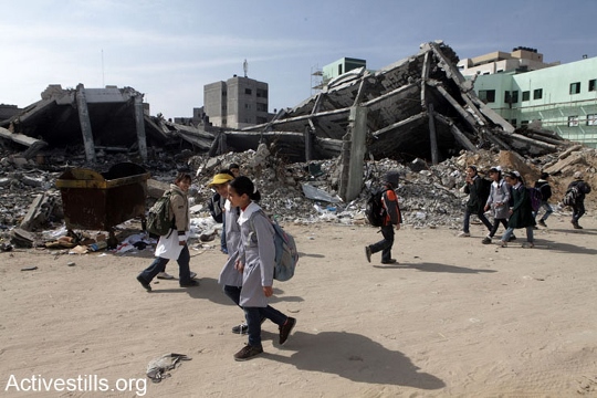 ילדים חולפים על פני חורבות משרד הפנים בעזה, אחרי הפצצה של חיל האוויר, 2013 (אקטיבסטילס)