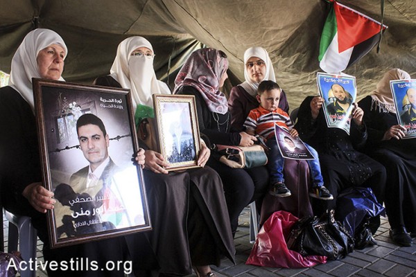 נשים פלסטיניות מחזיקות תמונות בסולדריות עם עצירים מנהליים השובתים רעב בבתי כלא ישראליים, שכם, הגדה המערבית, ה-28 לאפריל, 2014. (אחמד אל-באז/אקטיבסטילס) 