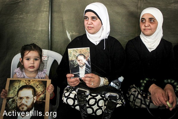 נשים פלסטיניות מחזיקות תמונות בסולדריות עם עצירים מנהליים השובתים רעב בבתי כלא ישראליים, שכם, הגדה המערבית, ה-2 במאי, 2014. (אחמד אל-באז/אקטיבסטילס) 