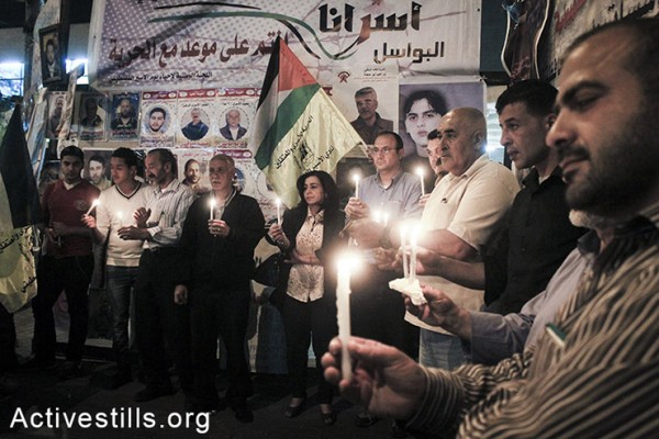 מחזיקים נרות באוהל מחאה אשר הוקם בסולידריות עם עצירים מנהליים שובתי רעב בבתי כלא ישראליים, שכם, הגדה המערבית, ה-3 למאי, 2014. (אחמד אל-באז/אקטיבסטילס) 
