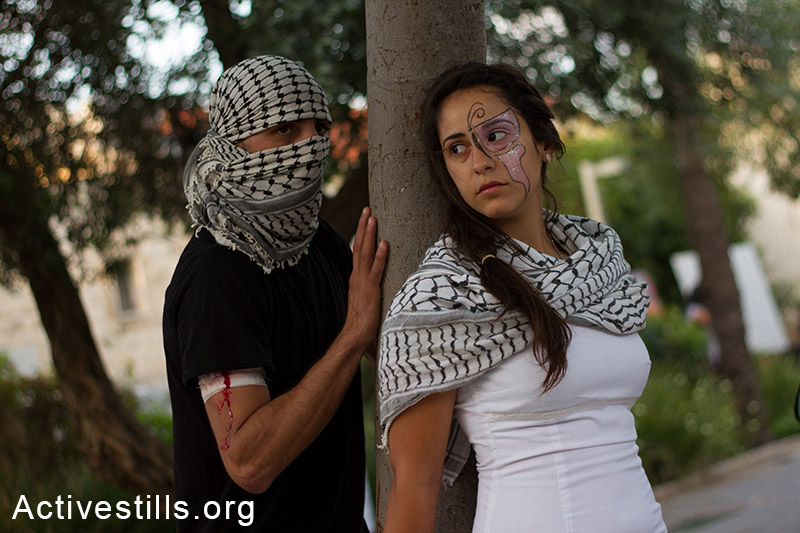 מיצג של צעירים פלסטינים, במהלך אירוע נגד התוכנית לגייס נוצרים פלסטינים אזרחי ישראל לצבא, חיפה, ה-17 במאי, 2014. (עומאר סאמיר/אקטיבסטילס)