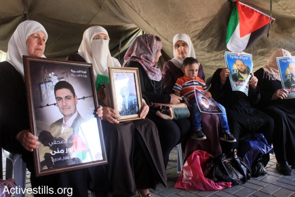 נשים פלסטיניות מחזיקות בתמונות אסירים פלסטינים באוהל מחאה בעיר שכם, ה- 28 לאפריל, 2014. מעל 100 אסירים פלסטינים הכלואים בבתי כלא ישראלים פתחו בשביתת רעב ב- 24 לאפריל 2014, במחאה על התנערות ישראל מהבטחתה להגביל את השימוש במעצרים מנהליים כלפי פלסטינים (אקטיבסטילס)