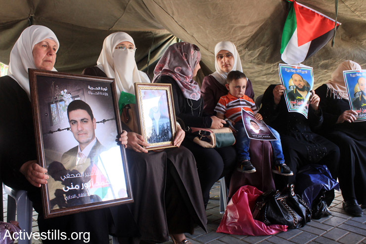 נשים פלסטינים מחזיקות תמונות של אסירים מנהליים באוהל מחאה שהוקם במרכז העיר שכם לתמיכה בשובתי הרעב (צילום: אקטיבסטילס)