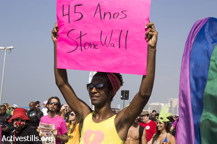 ג׳וב (המרואיין בכתבה) נושא שלט בהפגנה נגד גביע העולם בציון 45 שנה למצעד הלהטבי״ם הראשון, ריו דה ז׳נו, יוני 28, 2014. (מרייקה לואקן/אקטיבסטילס)