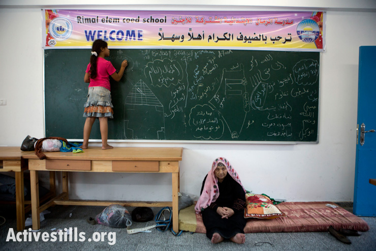 ילדה ממשפחת אל-טום מציירת על לוח בגיר בבית הספר היסודי של אונרווה שהוסב למקום מקלט עבור פליטים צפון-עזתיים שנסו מבתיהם לאחר התרעות הצבא, ה-13 ביולי, 2014. זו הפעם השלישית שהמשפחה בורחת מהתקפות ישראליות. אן פאק/אקטיבסטילס
