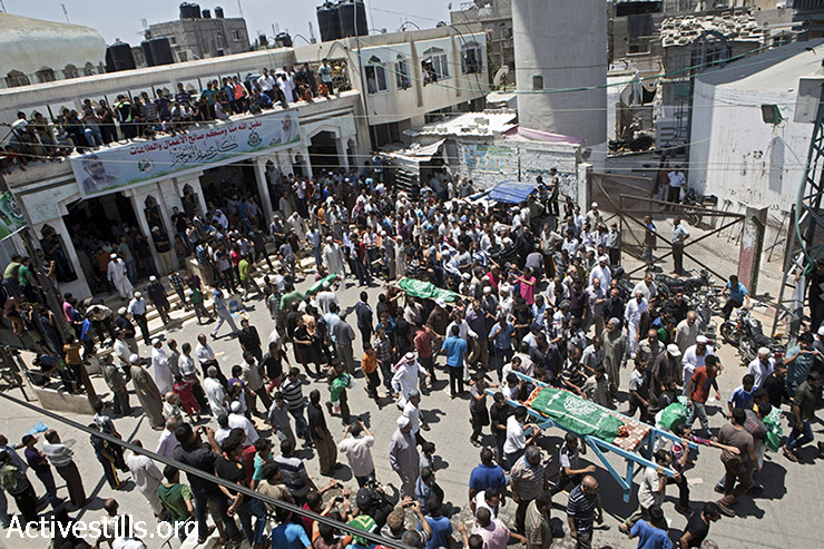 מתאבלים מוציאים את גופות בני משפחת אבו ג'מעה מהמסגד. חלק מהגופות נישאו בקופסאות קרטון עקב ביתורם כתוצאה מההפצצה (אן פק/אקטיבסטילס)