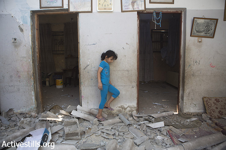 ביתו של דיאב בכר בין הריסות ביתה שהופצץ על ידי טילים ישראל לילה קודם. בית נוסף של משפחת בכר המורחבת נהרס כליל ואחר ניזוק בהפצצה. חסן חאדר בכר נהרג ברחוב בעת ההפצצה. מחנה הפליטים א-שאטי, עזה, 22 ליולי, 2014. (אן פאק/אקטיבסטילס)