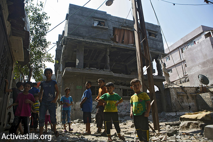 ילדים ממשפחת בכר המורחבת עומדים מחוץ לבתיהם ההרוסים במחנה הפליטים א-שאטי, בעיר עזה, 22 ביולי 2014. בני הדודים שלהם שגרים באותו האזור  עאהד (10), זכריא (10), מחמד (11) ואסמאעיל (9) נהרגו על ידי התקפות ישראליות בעת ששחקו על חוף הים, ב-16 ביולי 2014. (אן פאק/אקטיבסטילס)