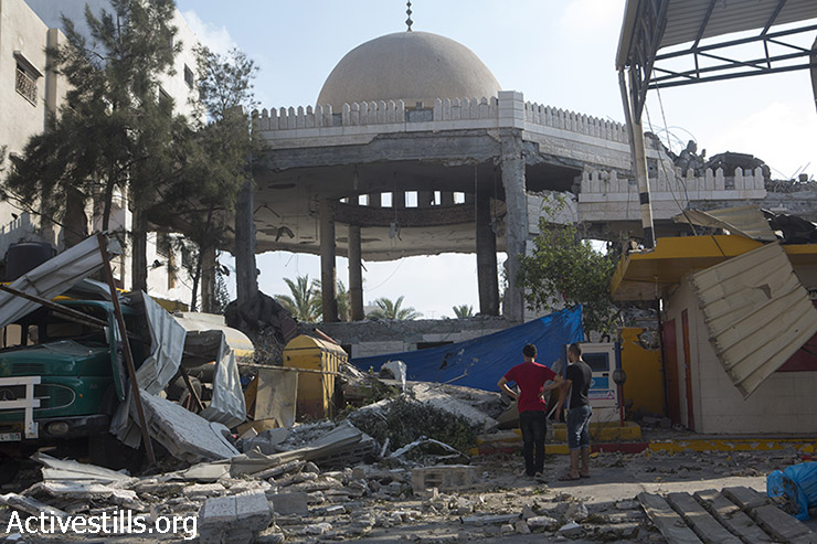 פלסטינים עומדים מול הריסות מסגד 'חללי אל אקצה' שהופצץ לילה קודם. עזה, 22 ביולי 2014. (אן פאק/אקטיבסטילס)