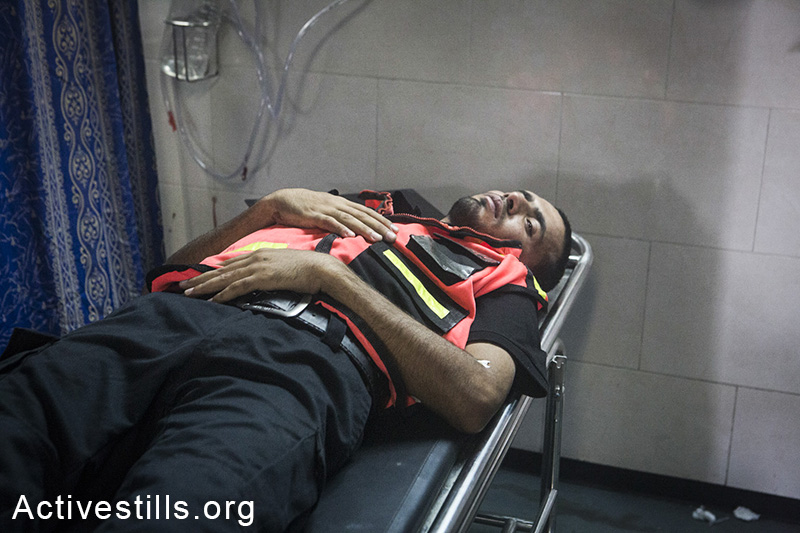 גופת פראמדיקי שנהרג מאש חיילים מובאת אל בית החולים אל-שיפא, עזה, ה-20 ליולי, 2014. (באסל יאזורי/אקטיבסטילס)