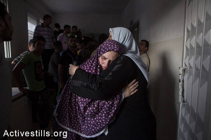 אימם של ג׳האד איסם שוהיבאר (8) ואאוסים איסם שוהיבר (7) מתאבלת על מותם שנהרגו בהתקפה ישראלית על שכונת סברה, עזה, ה-17 ליולי, 2014. (אן פאק/אקטיבסטילס)