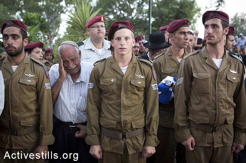 קרוב משפחה מתייפח מאחורי משמר חיילים מפלוגתו של החייל בניה רובן שנהרג במהלך המתקפה הישראלית בעזה. חולון, ה-20 ליולי, 2014 (אורן זיו/אקטיבסטילס)