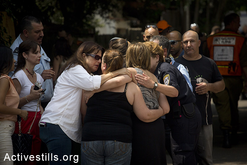 תושבי יהוד מתחבקים לאחר פגיעה ישירה של טיל באזור מגוריהם, ה-22 ליולי, 2014. (אורן זיו/אקטיבסטילס)