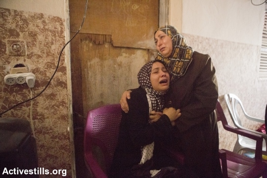 נשים ממשפחת אינת'ז מתאבלות על מותם של שלושה מבני המשפחה בהתקפה על שכונת אל-שג'עיה, 20.7.2014 (צילום: אן פאק / אקטיבסטילס)