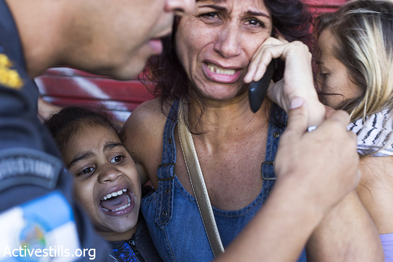 אמא וילדה שנקלעו לעימותים בזמן הפגנה נגד גמר גביע העולם בכדורגל, ריו דה-ז׳נרו, ברזיל, ה-13 ליולי, 2014, קרן מנור/אקטיבסטילס
