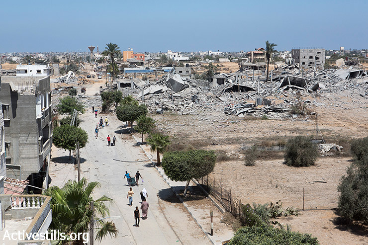 פלסטינים חוזרים לשכונת ח'וזאעה המופצצת, להוציא חפצים  וציוד אישי, ה- 3 באוגוסט 2014. (אן פאק / אקטיבסטילס)