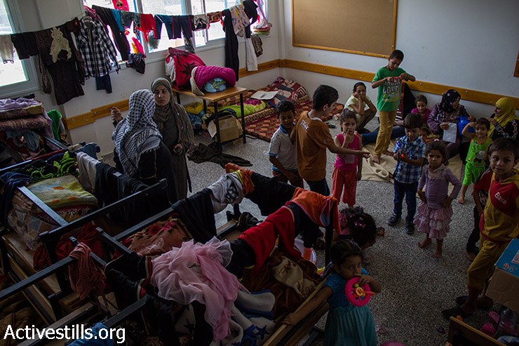 עקורות פלסטיניות ביום הראשון של עיד אל פיטר, שוהות בכיתה של בית הספר של אונר"א שהפך למקלט, ה-28 ביולי 2014. (באסל יאזורי / אקטיבסטילס)