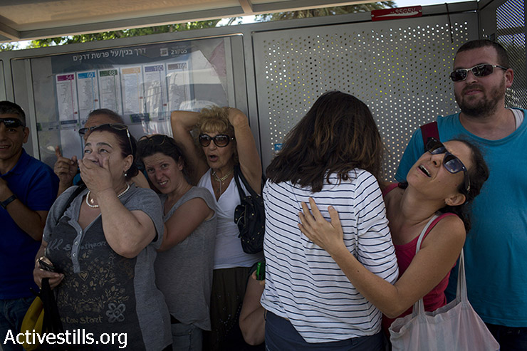 ישראלים תופסים מחסה בתחנת אוטובוס במרכז תל אביב בזמן אזעקה, 3 באוגוסט 2014. (אורן זיו / אקטיבסטילס)
