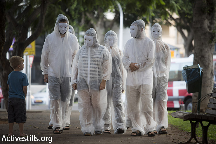 פעילים ישראליים הולכים בשדרות רוטשילד במרכז תל אביב, בפעולת סולידריות עם קורבנות המלחמה בעזה, 13 באוגוסט, 2014. (אורן זיו/אקטיבסטילס)