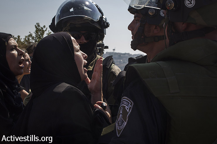 נשות נבי סאלח מתווכחות עם חיילים ישראליים, לאחר שנער פלסטיני נורה באש חיה ונלקח ע״י הצבא, במהלך ההפגנה השבועית בכפר נגד הכיבוש, 15 באוגוסט, 2014. (קרן מנור/אקטיבסטילס)
