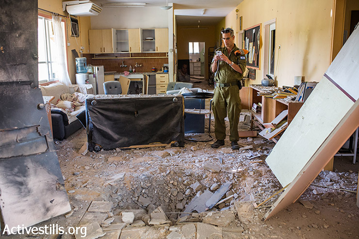 חייל ישראלי בודק בית שנפגע מפגיעה ישירה של מרגמה שנורתה מרצועת עזה, דרום ישראל, 21 באוגוסט 2014.  (יותם רונן/אקטיבסטילס)