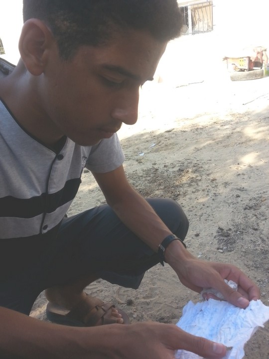 אחמד אבו-ראידה אוחז במכתב שכתב למשפחתו בזמן שהוחזק על ידי חיילים במשך חמישה ימים בעזה. (צילום: DCI-Palestine)