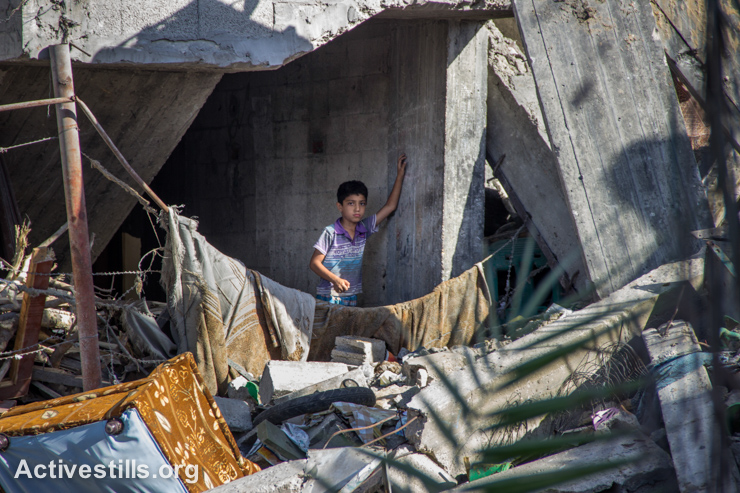 ילד פלסטיני עומד על חורבות ביתו בשכונת שג׳יעה, מזרח העיר עזה, ה-4 לספטמבר, 2014. (אקטיבסטילס)