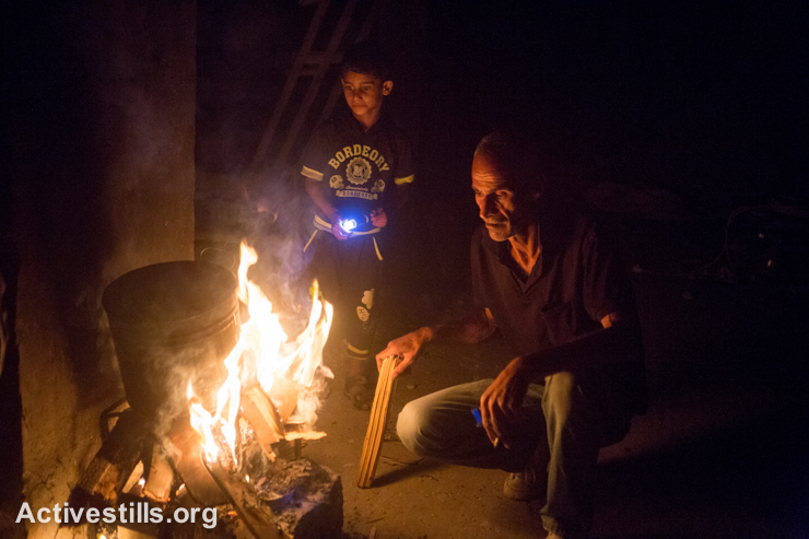 בני משפחת עאטש מדליקים אשר בחדר שנשאר על תילו בביתם ההרוס, שכונת שג׳יעה, ה-5 לספטמבר 2014. (אקטיבסטילס)