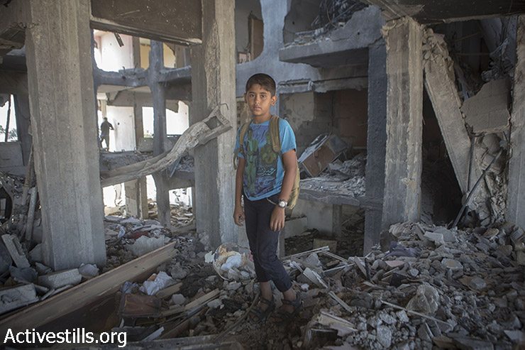 מוחמד, בן 11, עומד בין שרידי ביתו במגדלי אל נדא בבית חאנון שבצפון רצועת עזה לאחר שנהרסו על ידי הפצצות ישראליות. 21 בספטמבר, 2014. במגדלים היו 90 דירות, בהם התגוררו משפחות רבות.(אקטיבסטילס)