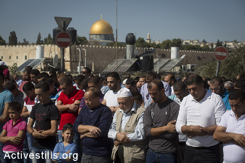 פלסטינים מבצעים את תפילת יום השישי, בשכונת ראס אל-עמוד, במזרח ירושלים, 24 אוקטובר, 2014. (אקטיבסטילס)