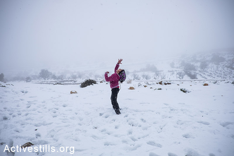 ילדה פלסטינית משחקת בשלג במהלך סופת חורף, הגדה המערבית, 10 ינואר, 2015. אקטיבסטילס