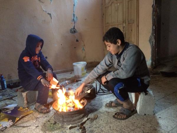 ילדים מתחממים אתמול במה שנותר מביתם בסוג'עיה , עזה. צילום: Dan Cohen