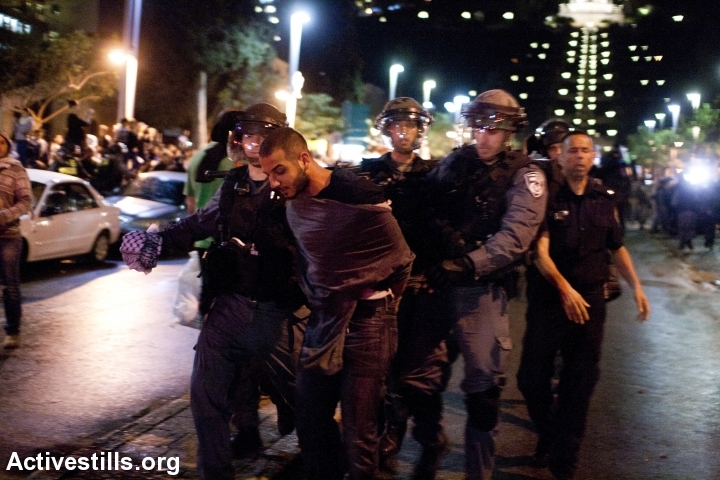 שוטרים עוצרים מפגין בהפגנה נגד תוכנית פראוור, חיפה, נובמבר 13' (קרן מנור / אקטיבסטילס)