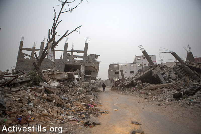 פלסטיני הולך בשכונת שג׳עיה במהלך סופת חורף, רצועת עזה, 12 פברואר, 2015. אן פאק / אקטיבסטילס