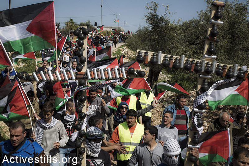 כאלף מפגינים – פלסטינים, ישראלים ובינלאומיים צועדים במהלך הפגנה לציון עשר שנים של מאבק עממי בכפר בלעין נגד חומת ההפרדה, שעוברת על אדמות הכפר. 27 בפברואר, 2015. עוד בנושא
