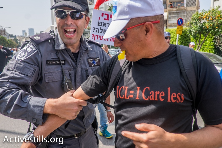 עובד כי"ל ושוטר בהפגנה בתל אביב (יותם רונן / אקטיבסטילס)