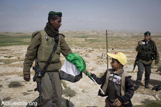 חייל מנסה לחטוף מילד דגל פלסטין. דרום הר חברון, מרץ 2013. (אורן זיו/אקטיבסטילס)