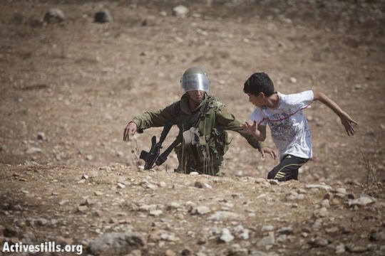 חייל מנסה לעצור ילד פלסטיני במהלך הפגנה בנבי סלאח. ספטמבר 2012 (אורן זיו/אקטיבסטילס)