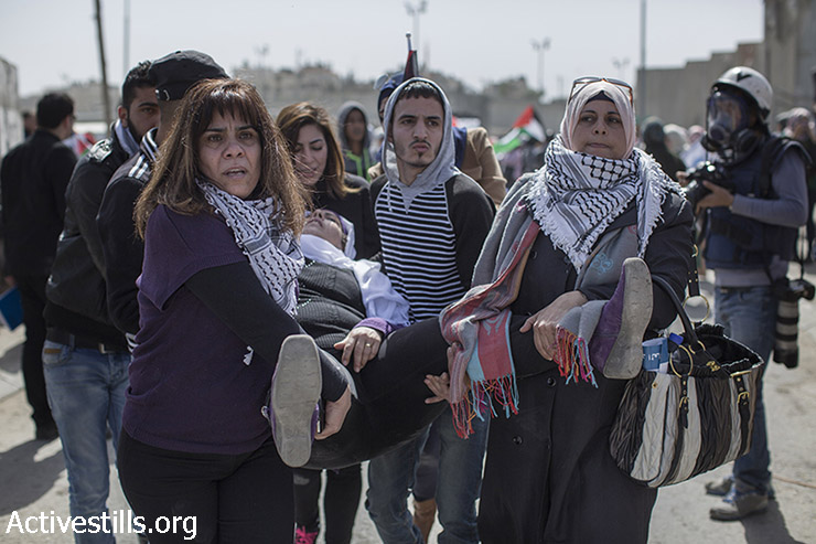 פעילות מפנות פלסטינית שנפצעה במהלך צעדת יום האישה הבינ״ל, סמוך למחסום קלנדיה, 7 במרץ, 2015. (אקטיבסטילס)