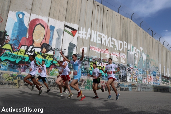 רצים לצד חומת ההפרדה בבית לחם. מרתון 2015. (אחמד אל-באז/אקטיבסטילס)