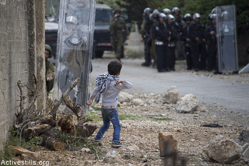 ילד זורק אבן על חיילים במהלך הפגנה נגד הכיבוש בכפר קדום, הגדה המערבית, 15 מאי, 2015. אכרם דראוושי / אקטיבסטילס