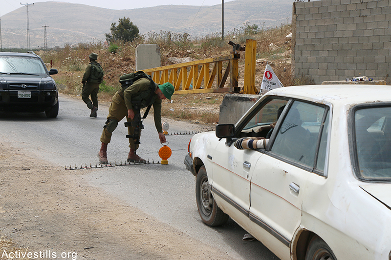 חיילים מקימים מחסום תנועה לבדיקת מכוניות, הכפר פוריק ליד שכם, הגדה המערבית, 17 מאי, 2015. אחמד אל-באז / אקטיבסטילס