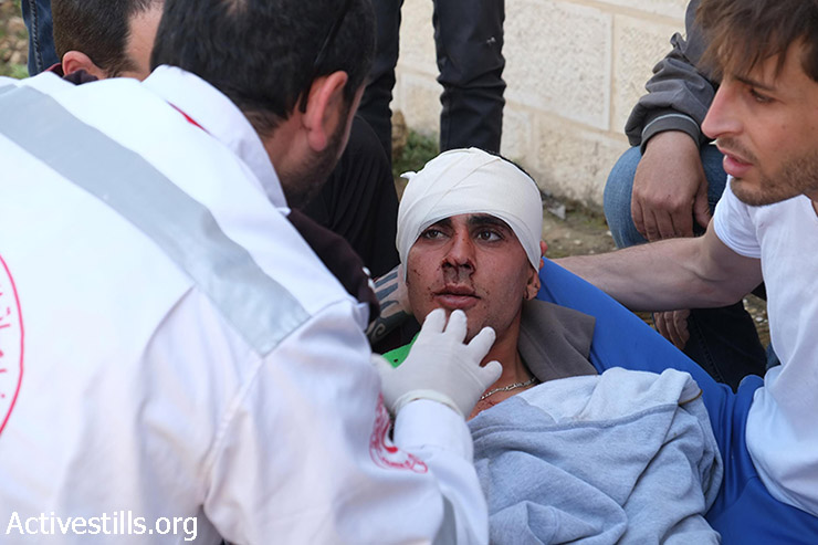 צעיר פלסטיני שנורה בראשו מתחמושת חייה, מטופל ע״ חובש במהלך ההפגנה השבועית נגד הכיבוש בכפר נבי סאלח, 24 באפריל, 2015.