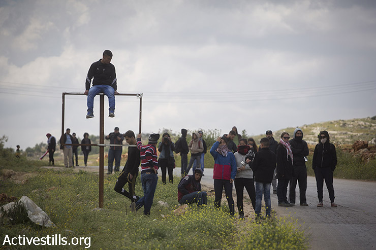 צעירים פלסטינים עומדים על הכביש הראשי בכפר נבי סאלח במהלך ההפגנה השבועית נגד הכיבוש. 10 באפריל, 2015.