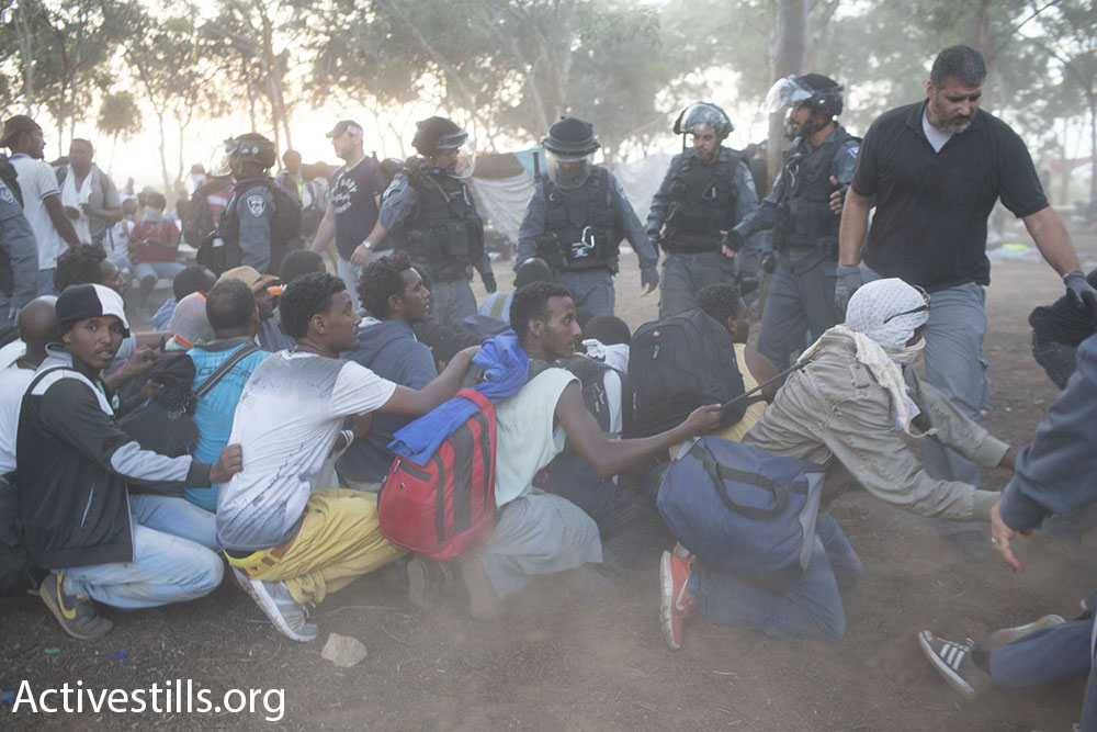 מבקשי מקלט אוחזים אחד בשני בזמן ששוטרים מפנים אותם באלימות ממחנה המחאה שהקימו ליד גבול מצרים (אקטיבסטילס)