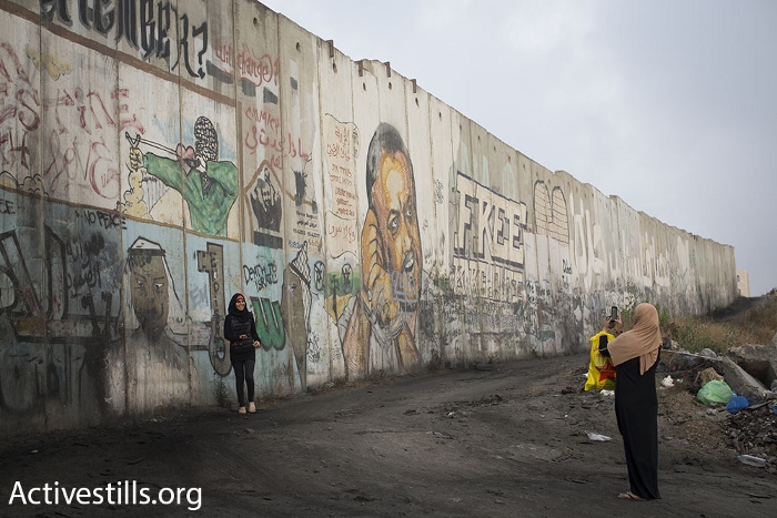 נשים מצטלמות ליד חומת ההפרדה, קלנדיה (אורן זיו / אקטיבסטילס)