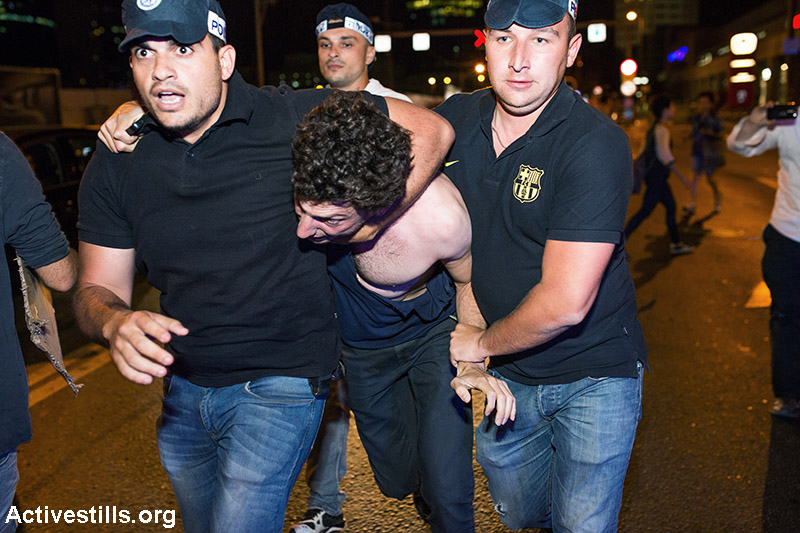 שוטרים עוצרים מפגין במהלך הפגנה נגד הפרטת משאבי הגז הטבעי שנמצאו בים התיכון, תל אביב, 27 ביוני 2015. כ-4000 איש/ה השתתפו בהפגנה שבמהלכה נחסמו כבישים רבים לשעות ארוכות. במקום נעצרו לפחות שישה מפגינים, אך חלקם שוחררו מאוחר יותר בשטח, ורק ארבעה מהם נלקחו לתחנת המשטרה, שם נחקרו בחשד לתקיפות שוטרים. קרא/י עוד. (יותם רונן/ אקטיבסטילס)