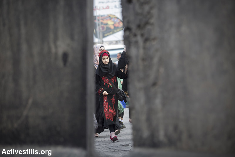 פלסטיניות חוצות את מחסום קלנדיה בין רמאללה וירושלים  בדרכם לתפילה במסגד אל-אקצא בירושלים, ביום שישי השני של חודש הרמדאן, 26 ביוני 2015. (אורן זיו/אקטיבסטילס)